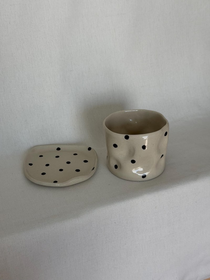 Polka cup and saucer, a handbuilt ceramic cup with black dots on a matching saucer, 8 oz