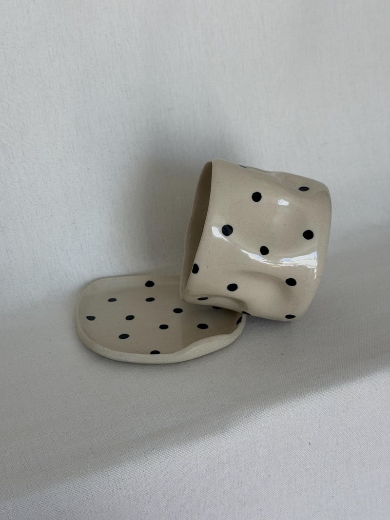 Polka cup and saucer, a handbuilt ceramic cup with black dots on a matching saucer, 8 oz